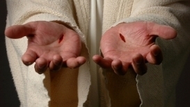 The hands of Jesus extended, with the marks of the nails showing
